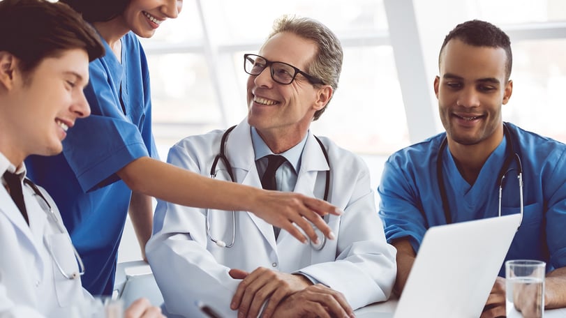 Hospital staff talking and smiling in a meeting