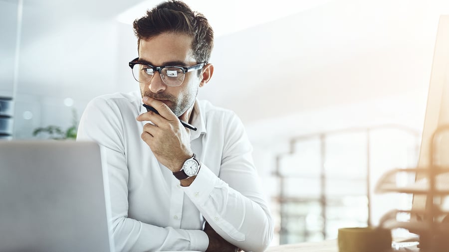 A businessman contemplating something on a laptop.