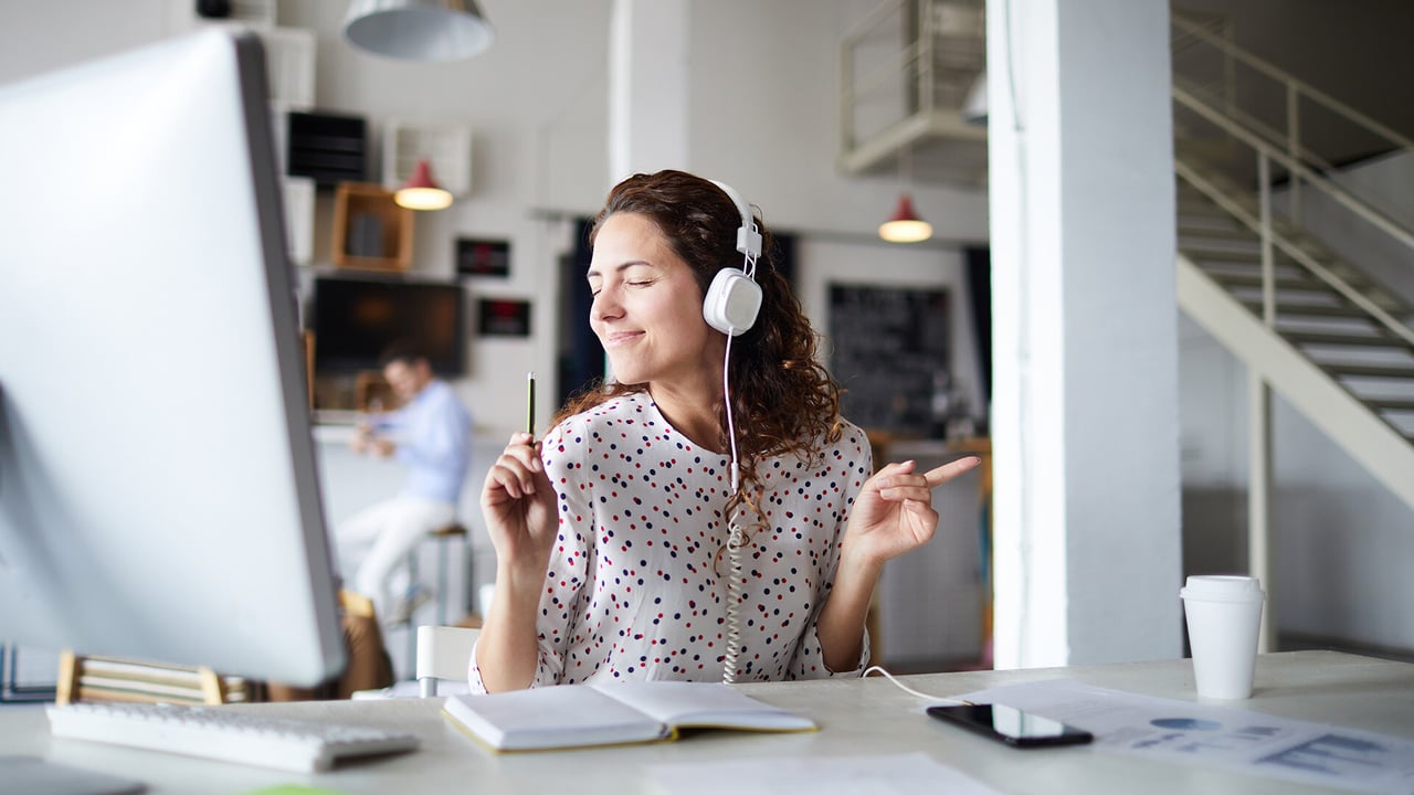 Woman listening to music at an office.