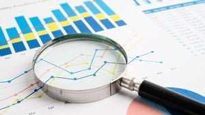 A magnifying glass examining a spreadsheet with Multiview's colors