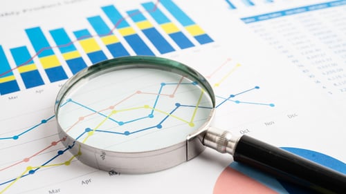 A magnifying glass examining a spreadsheet with Multiview's colors